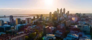Real estate agent pointing at a map of Perth with property valuation markers.